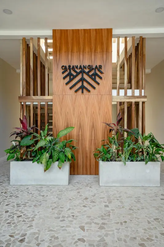 Entree d'un batiment avec un mur en bois et des plantes decoratives.