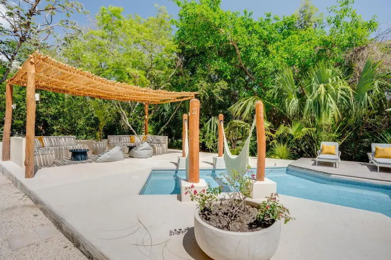 Espace de détente extérieur avec pergola et petite piscine.