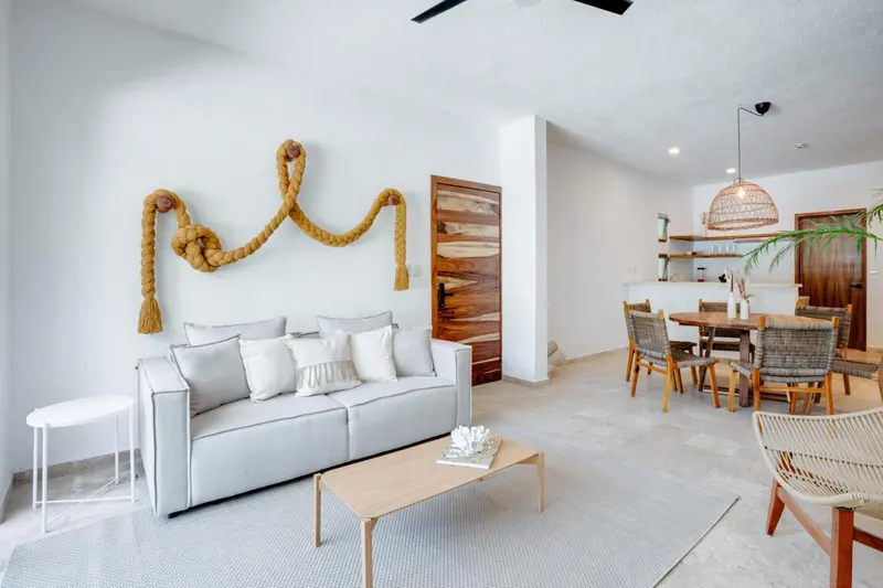 Un salon clair avec un canapé gris et une table basse en bois.