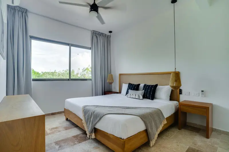 Une chambre lumineuse avec un grand lit et une décoration sobre.