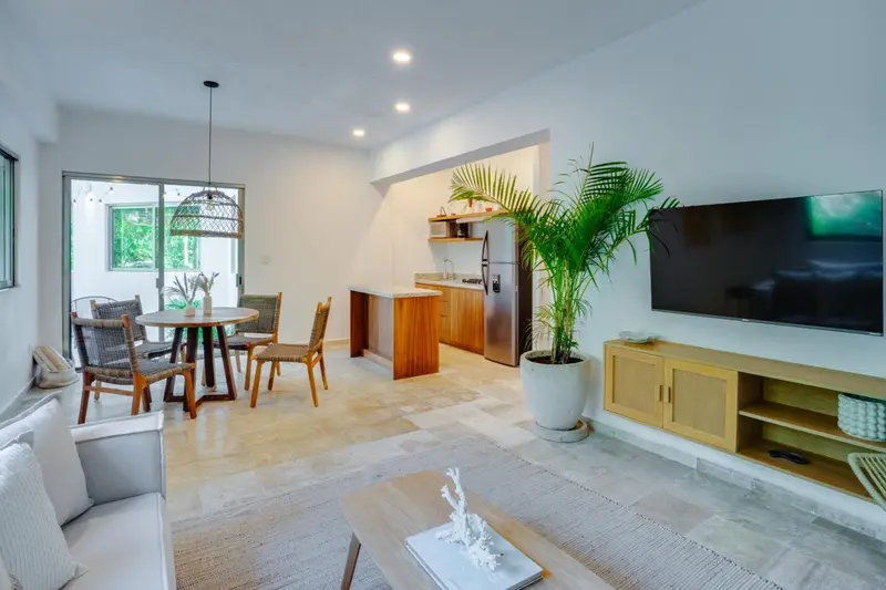 Espace de vie lumineux avec coin repas et cuisine ouverte.