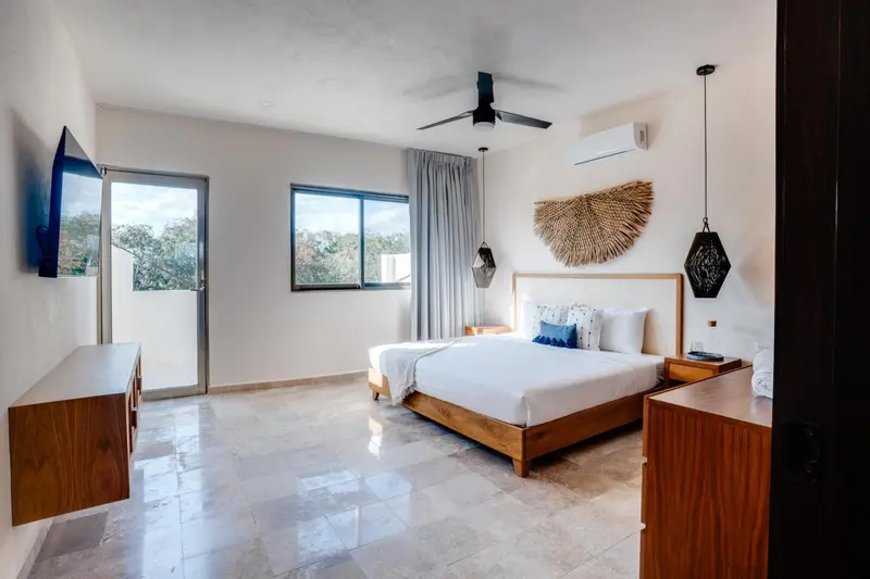 Une chambre lumineuse avec un grand lit et une décoration sobre.