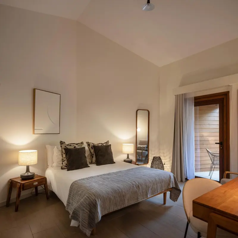 Une chambre lumineuse avec un grand lit et une décoration sobre.