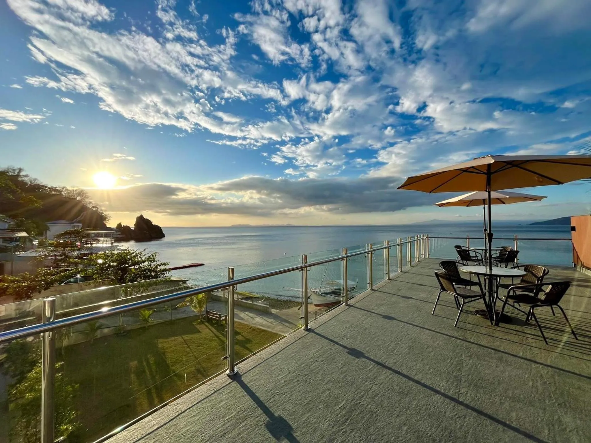 Terrasse avec mobilier de jardin et vue sur la mer.