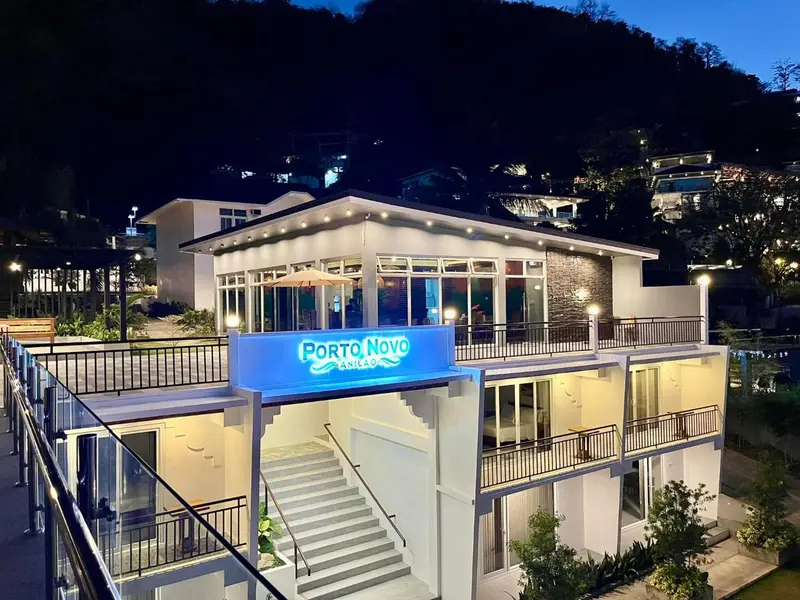 Bâtiment moderne éclairé avec une terrasse et des escaliers extérieurs.