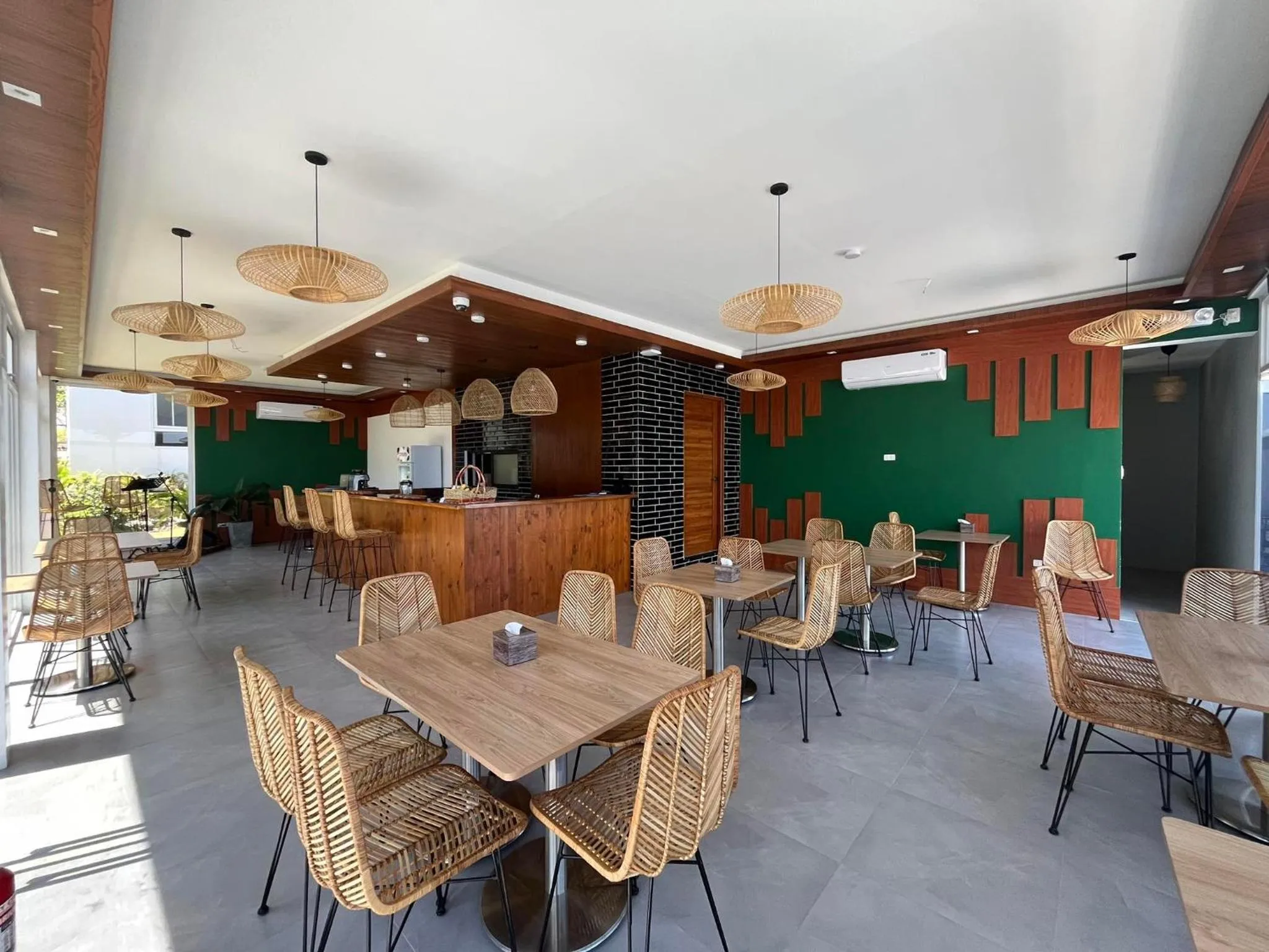 Une salle de restaurant lumineuse avec des tables et des chaises en rotin.