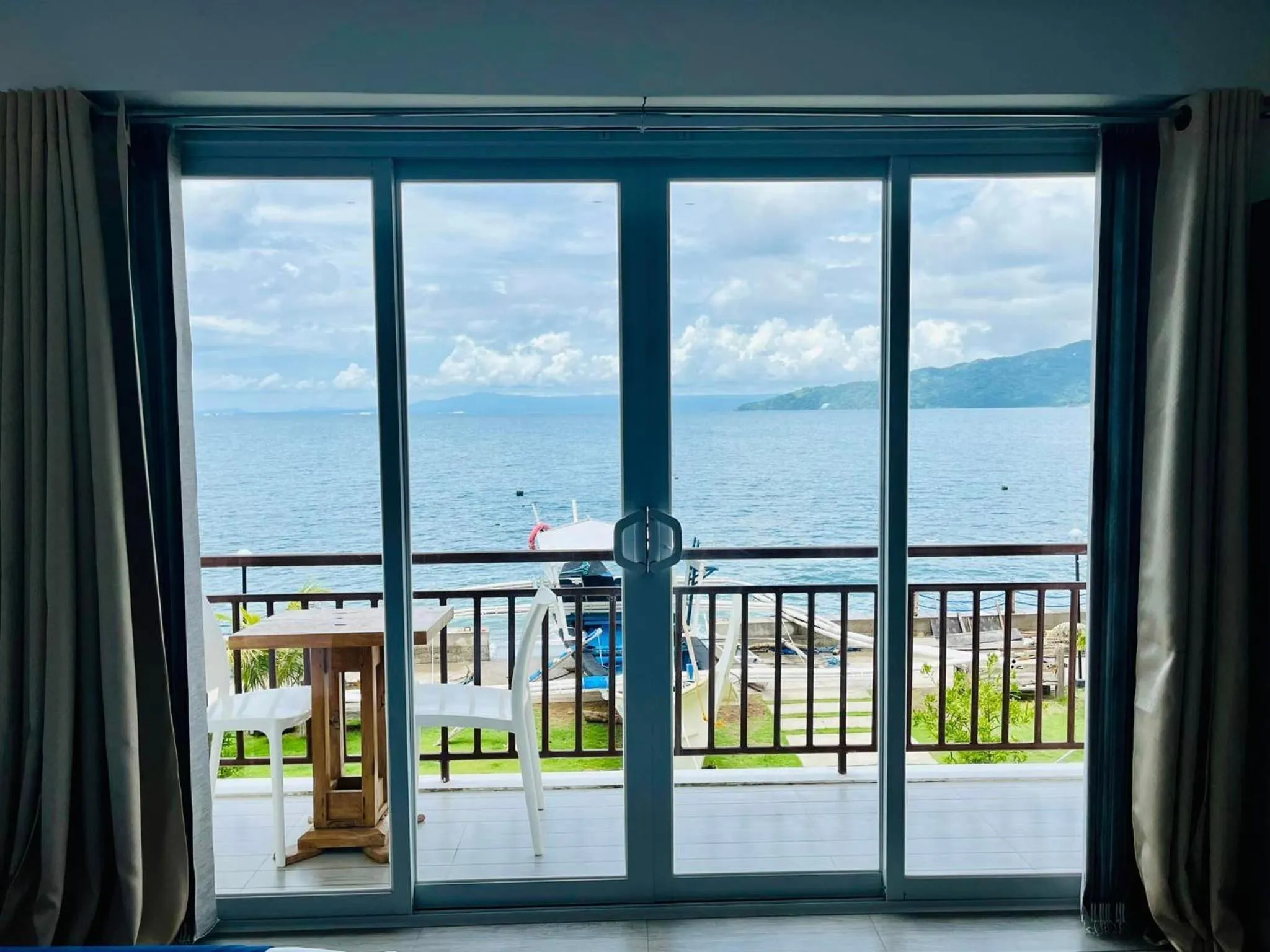 Vue sur la mer depuis une terrasse avec mobilier d'extérieur.