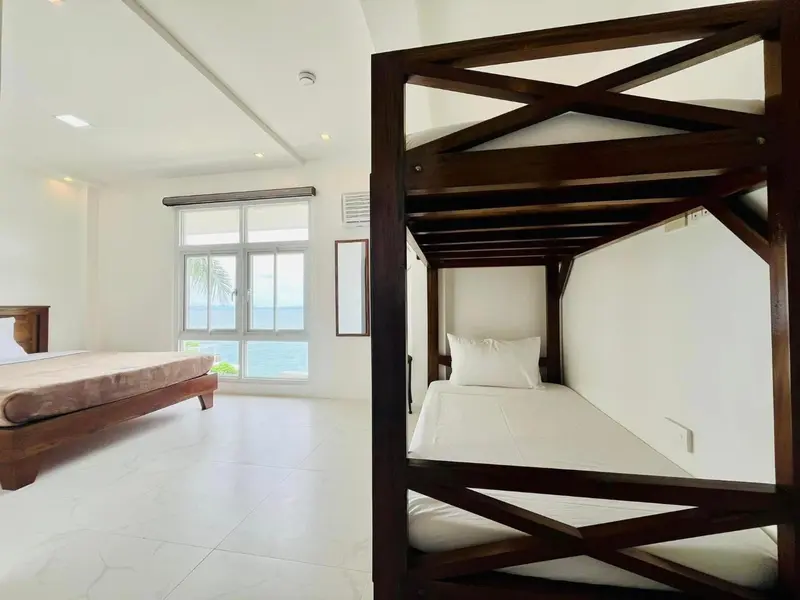 Une chambre lumineuse avec un lit simple et un lit double.
