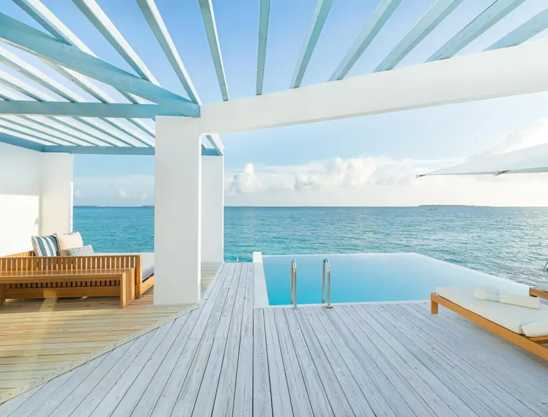 Terrasse en bois avec piscine à débordement donnant sur l'océan.