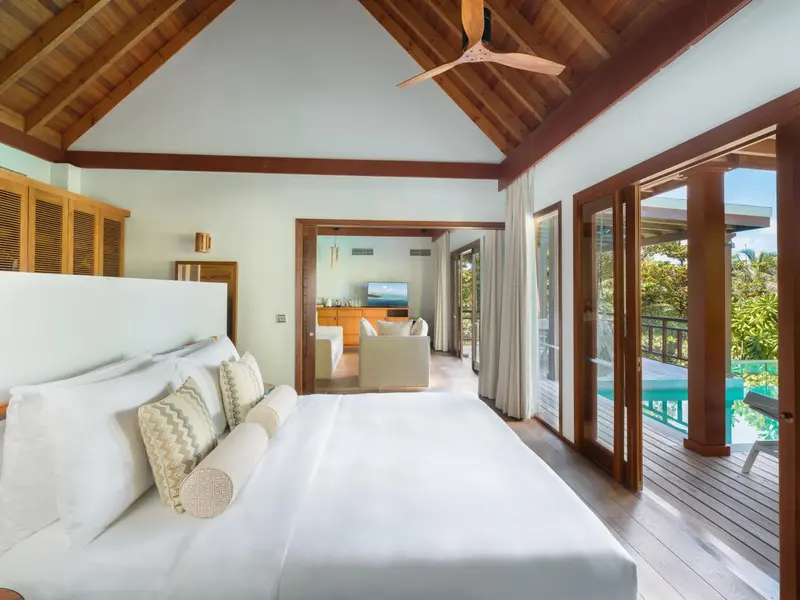 Une chambre lumineuse avec un grand lit et un accès à une terrasse.