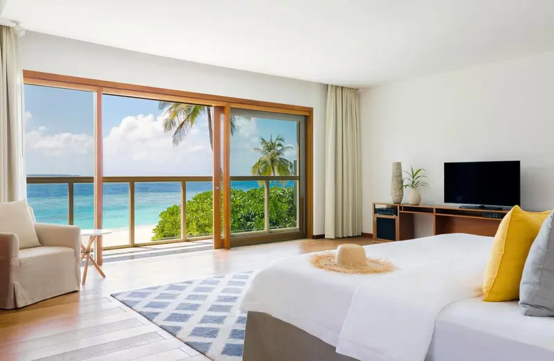 Une chambre lumineuse avec un grand lit donnant sur une vue sur la mer.