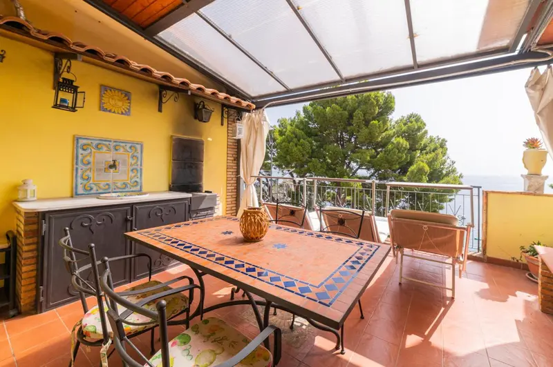 Une table à manger en extérieur avec vue sur la mer.