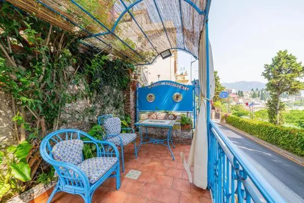 Terrasse ombragée avec mobilier de jardin et vue sur la végétation.