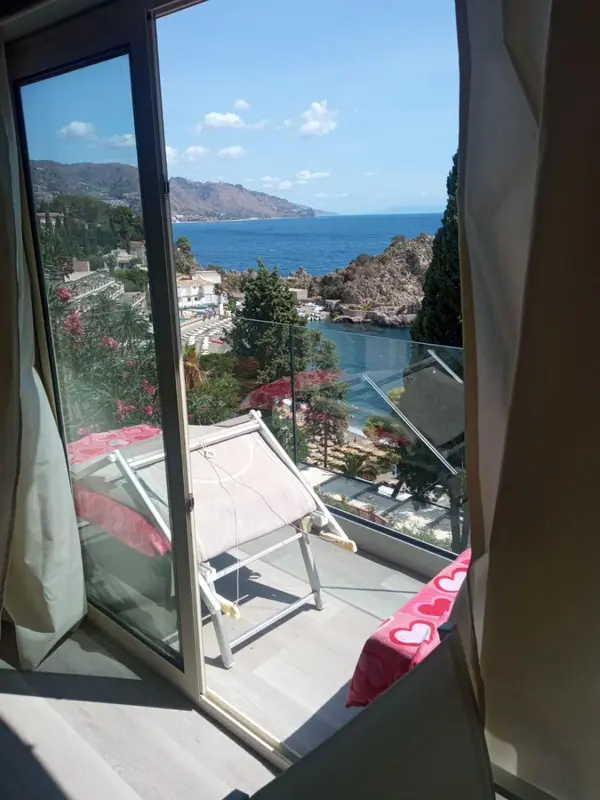 Vue sur la mer et les collines depuis une terrasse.