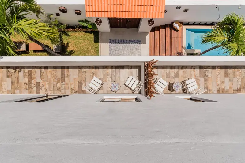 Terrasse avec chaises longues et piscine au premier plan.