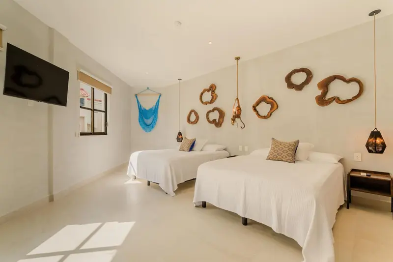 Une chambre lumineuse avec deux lits simples et une décoration murale originale.