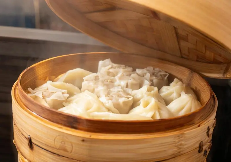 Vaporisation de raviolis dans un panier en bambou.