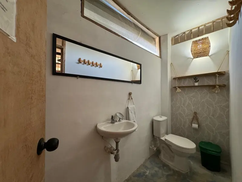 Petite salle de bain avec lavabo, toilettes et décoration murale en bois.