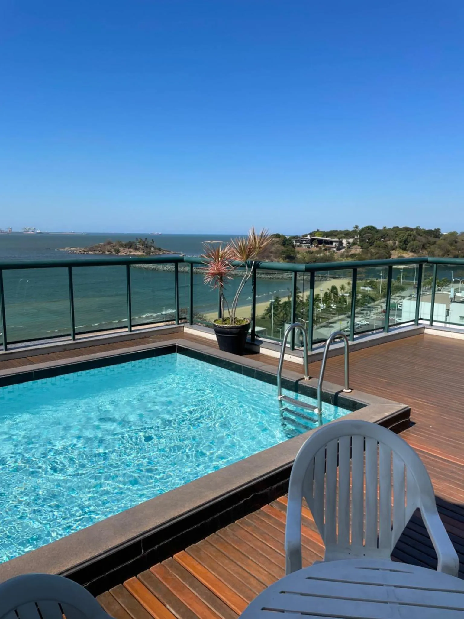 Une piscine sur une terrasse avec vue sur la mer et le paysage environnant.