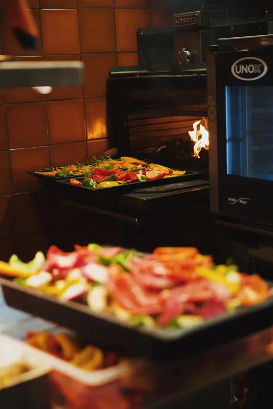 Préparation de plats colorés sur un grill professionnel.