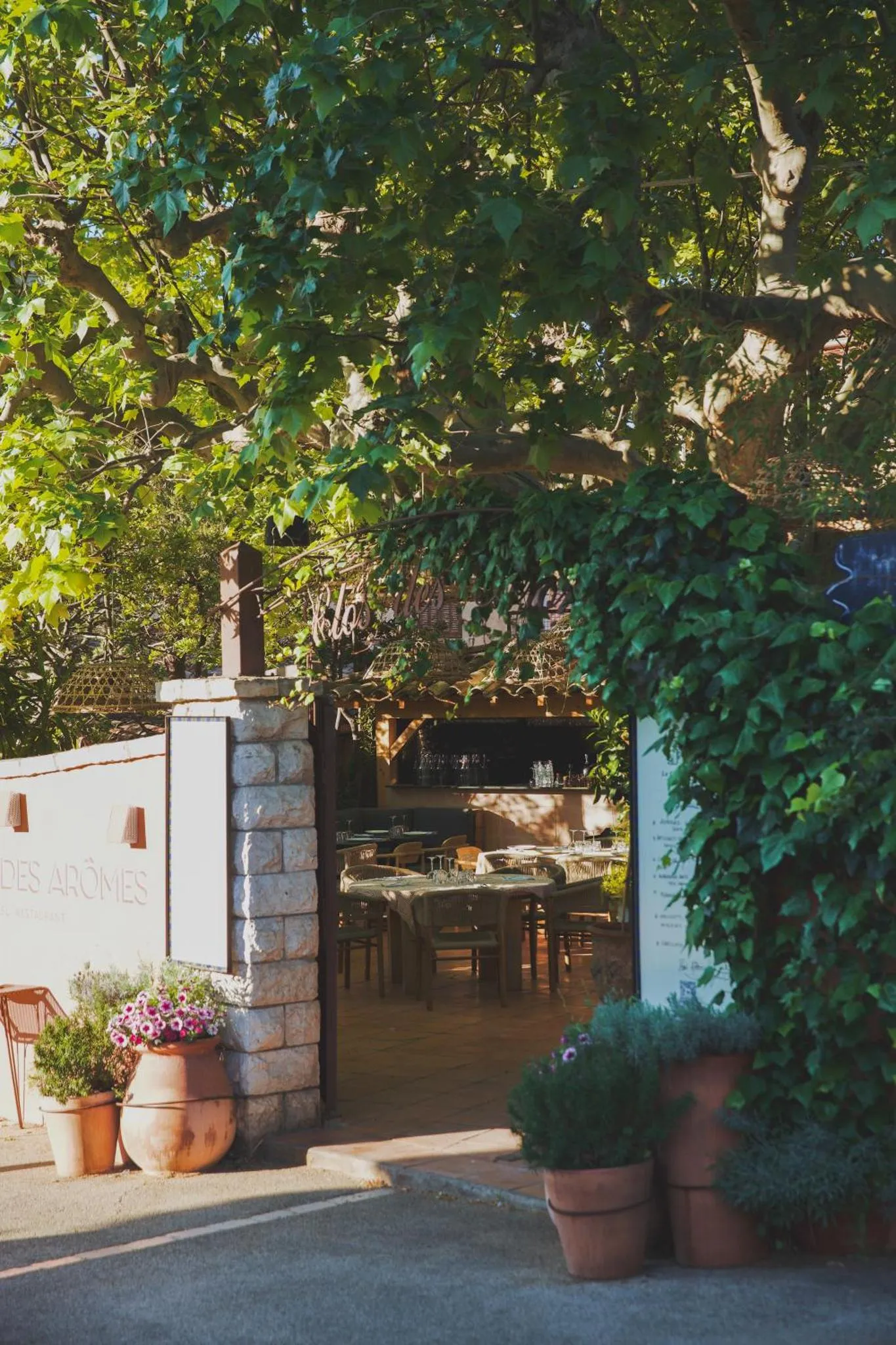 Une terrasse ombragée avec des tables et des chaises.