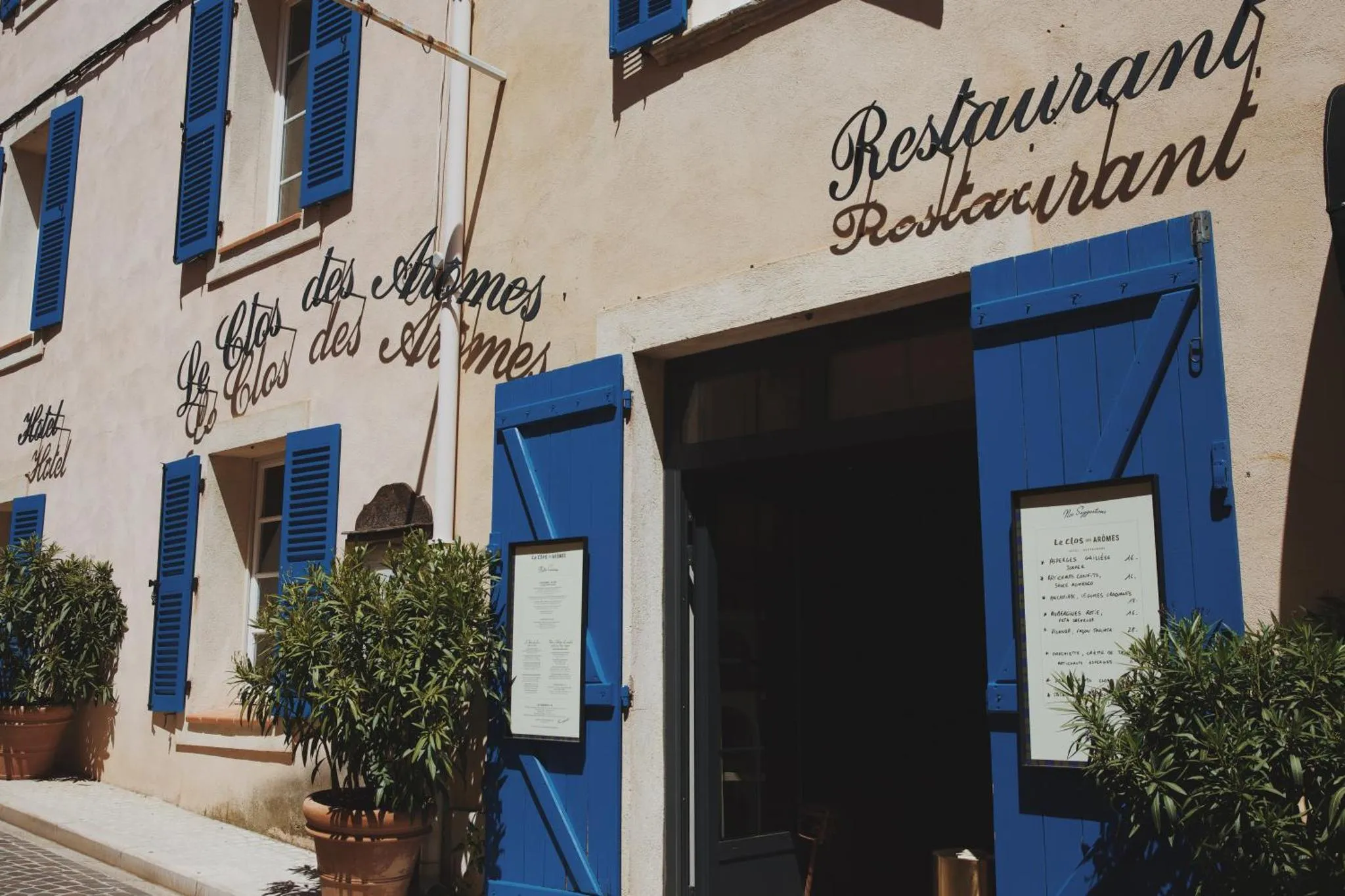 Façade d'un bâtiment avec des volets bleus et une enseigne.