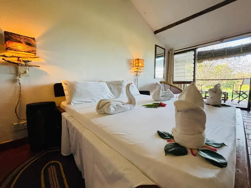 Une chambre lumineuse avec un lit soigneusement fait et des décorations florales.