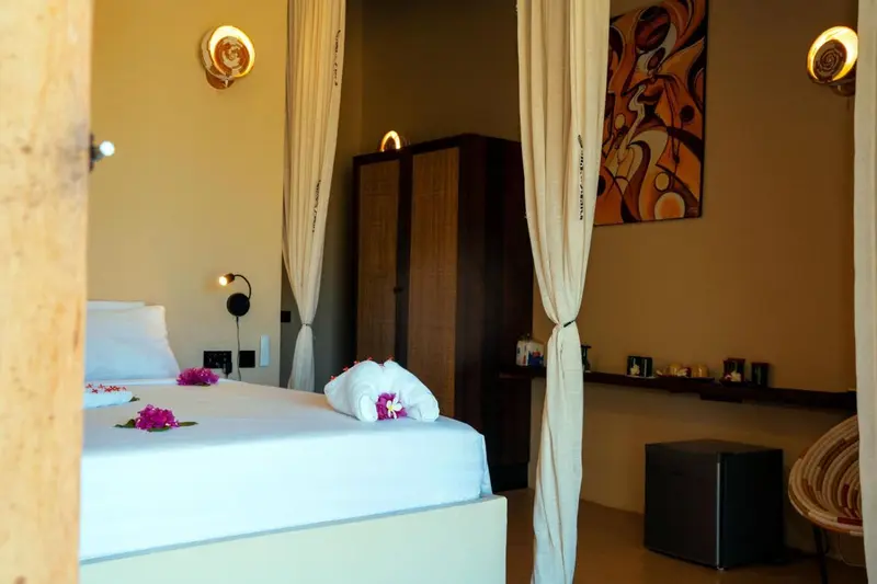 Une chambre lumineuse avec un lit décoré de fleurs et un espace détente.