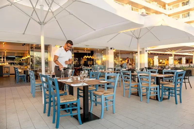 Une terrasse de restaurant avec des tables et des chaises bleues.