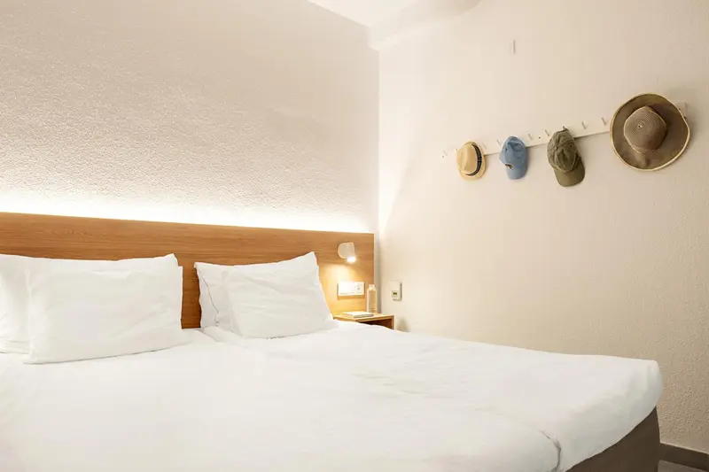 Lit blanc préparé dans une chambre lumineuse.