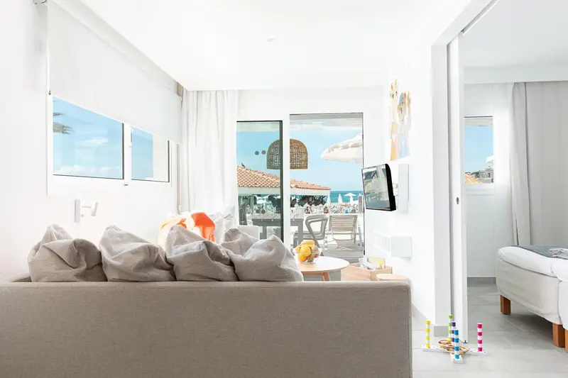 Espace de détente lumineux avec canapé et vue sur la mer.