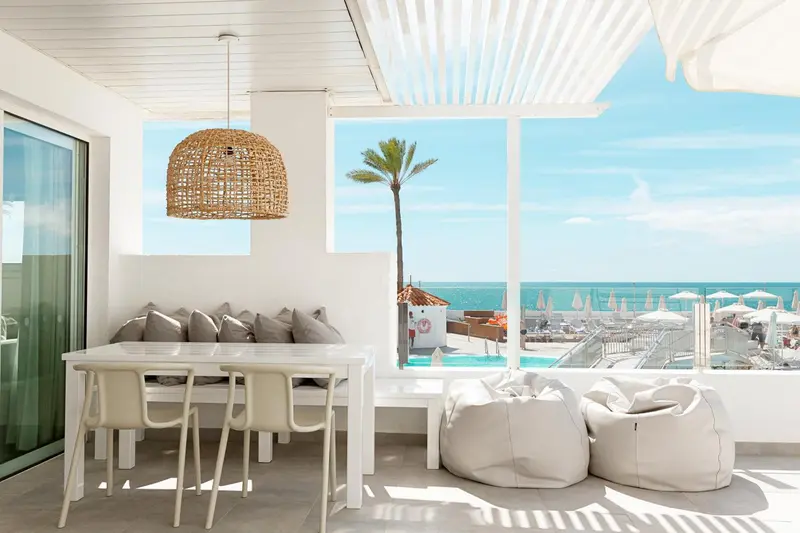 Espace repas lumineux avec vue sur la mer et la plage.
