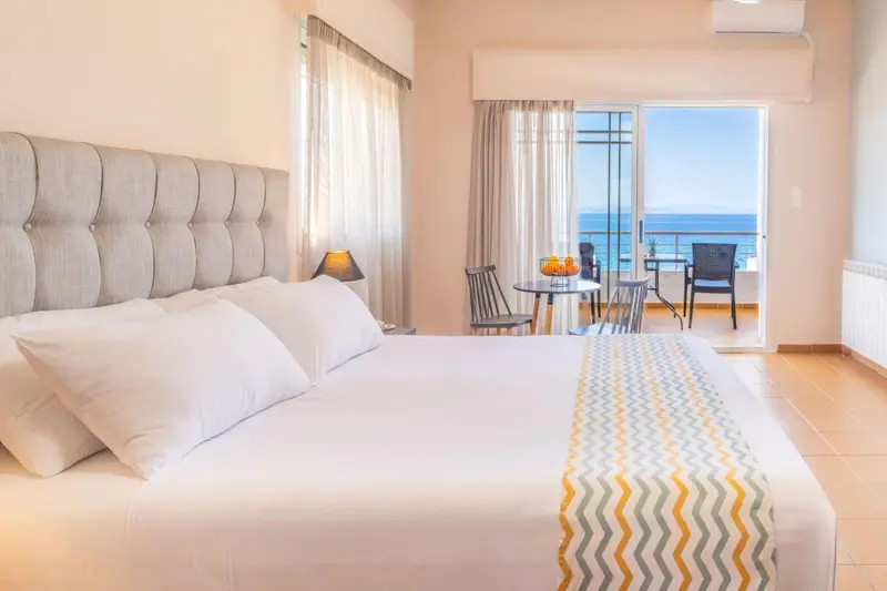 Une chambre lumineuse avec un grand lit et un accès à une terrasse.
