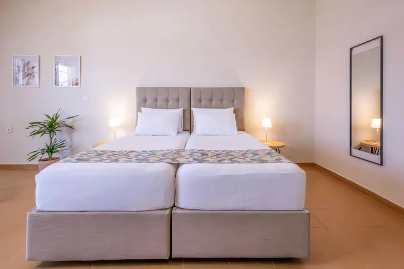 Une chambre lumineuse avec un grand lit et des illustrations murales.