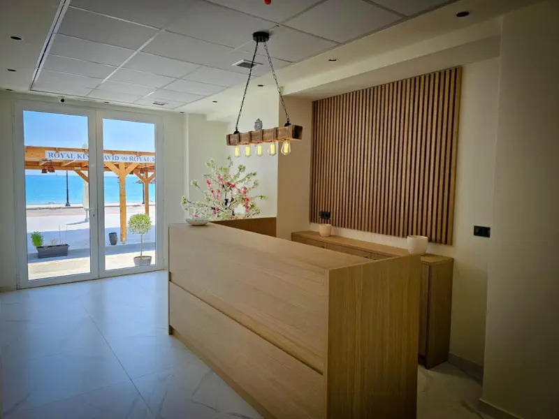 Un comptoir d'accueil lumineux donne sur une vue de plage et de mer.