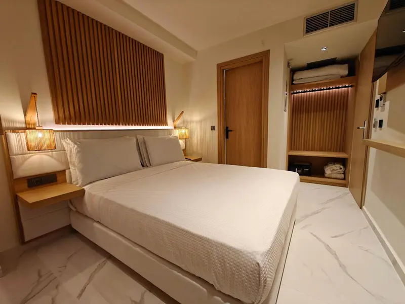 Une chambre lumineuse avec un grand lit recouvert d'une courtepointe blanche.