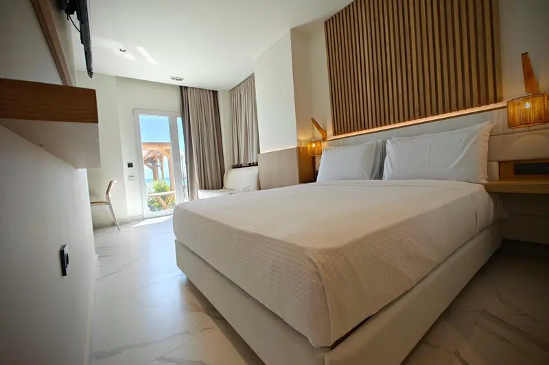 Une chambre lumineuse avec un grand lit et une vue sur la mer.