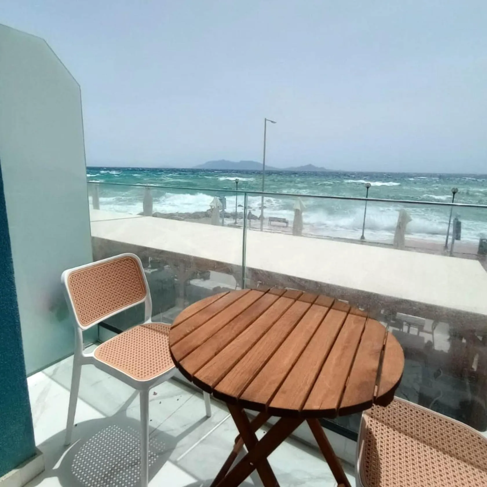 Terrasse avec mobilier en bois et vue sur la mer.