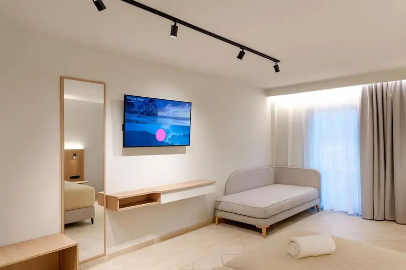 Une pièce lumineuse avec un canapé et un téléviseur mural.