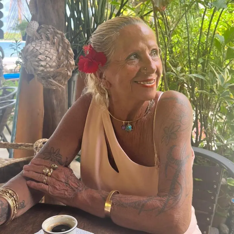 Portrait d'une femme souriante assise en extérieur.