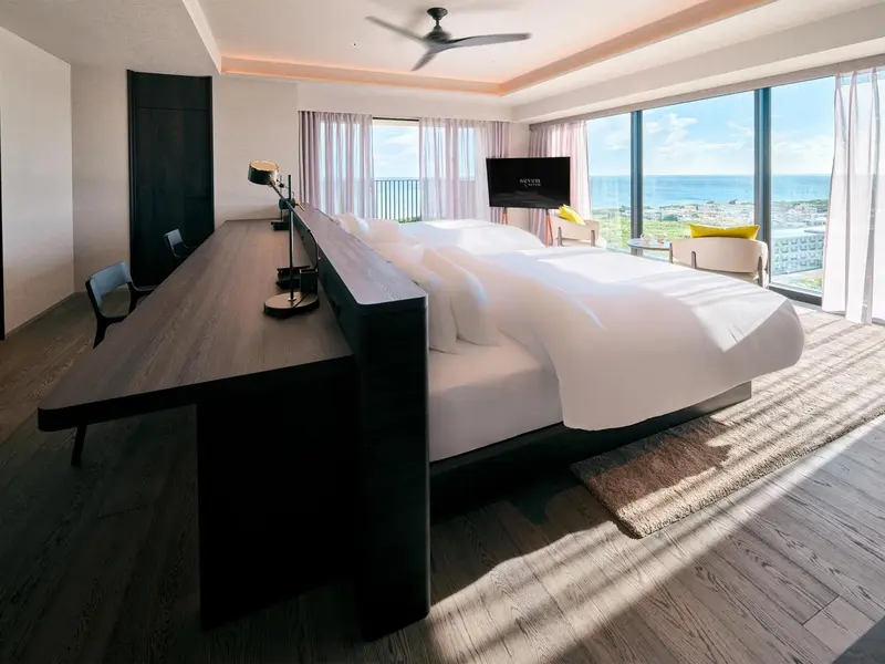 Une chambre lumineuse avec un grand lit et une vue sur la mer.