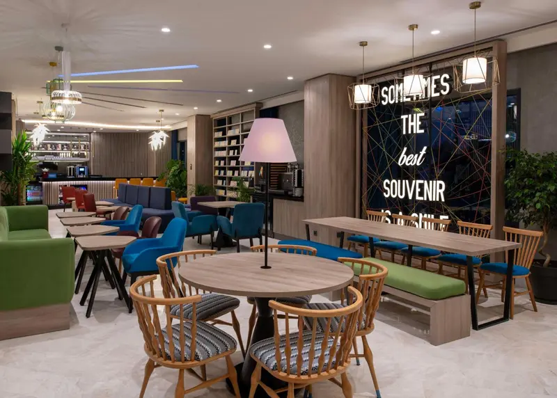 Espace de détente avec tables, chaises et luminaires décoratifs.