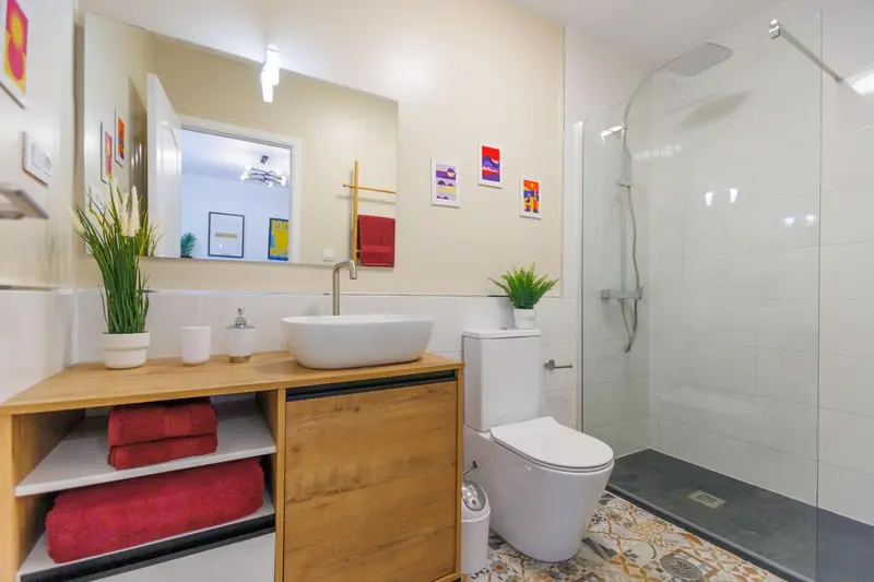 Une salle de bain moderne avec douche à l'italienne et vasque sur meuble.