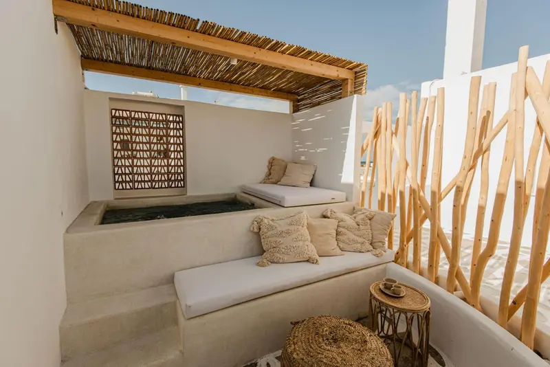Espace de détente extérieur avec assise intégrée et coussins.