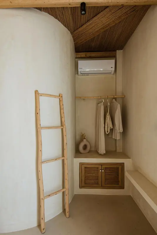 Intérieur d'une chambre avec une échelle en bois et un placard intégré.