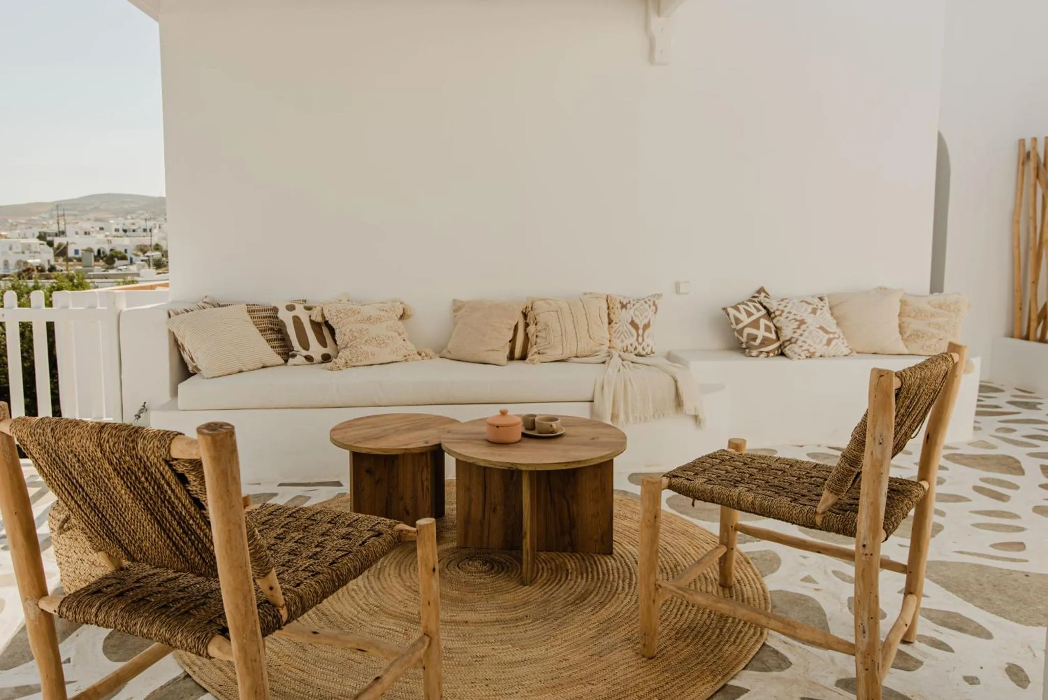 Espace de détente extérieur avec canapés et tables basses en bois.