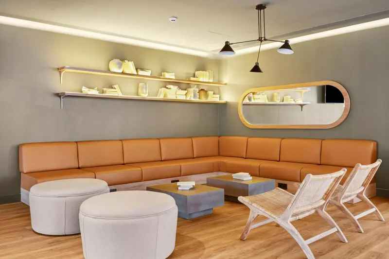 Espace de détente avec banquette en cuir et luminaires suspendus.