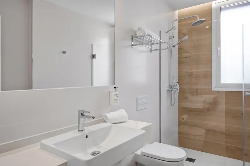 Une salle de bain moderne avec douche à l'italienne et lavabo blanc.