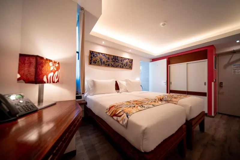 Une chambre lumineuse avec un grand lit et une décoration murale.