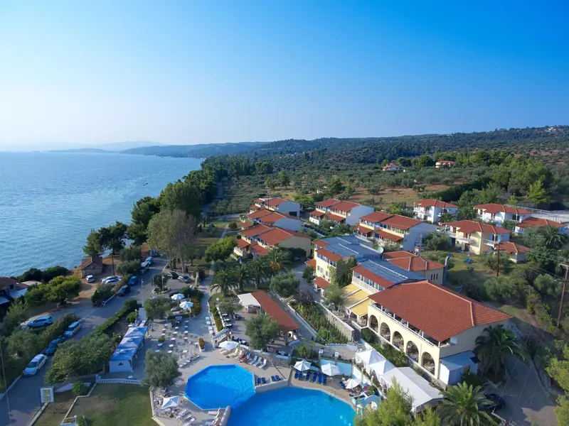 Vue aérienne d'un complexe hôtelier avec piscine et végétation luxuriante.